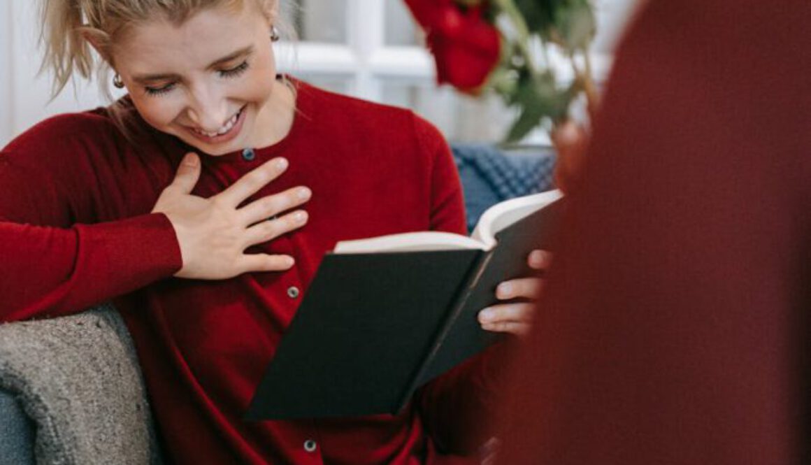 woman in red sweater reading a book